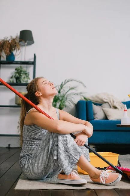 Asian couple having fun while cleaning their home, enhancing a cheerful atmosphere.
